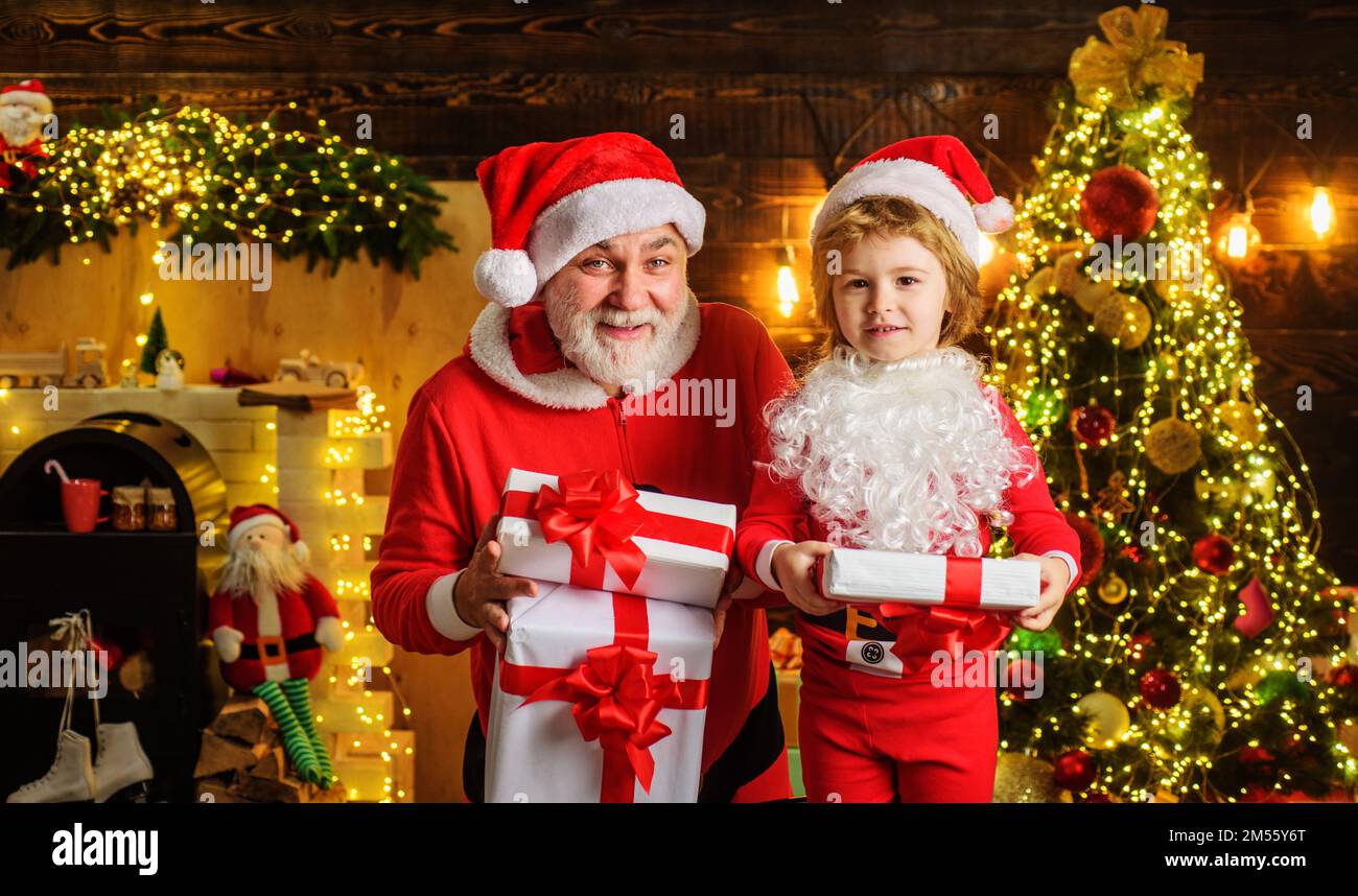 Petit enfant et Père Noël avec boîte cadeau à la veille de Noël. Vacances d'hiver en famille. Bonne Année. Banque D'Images