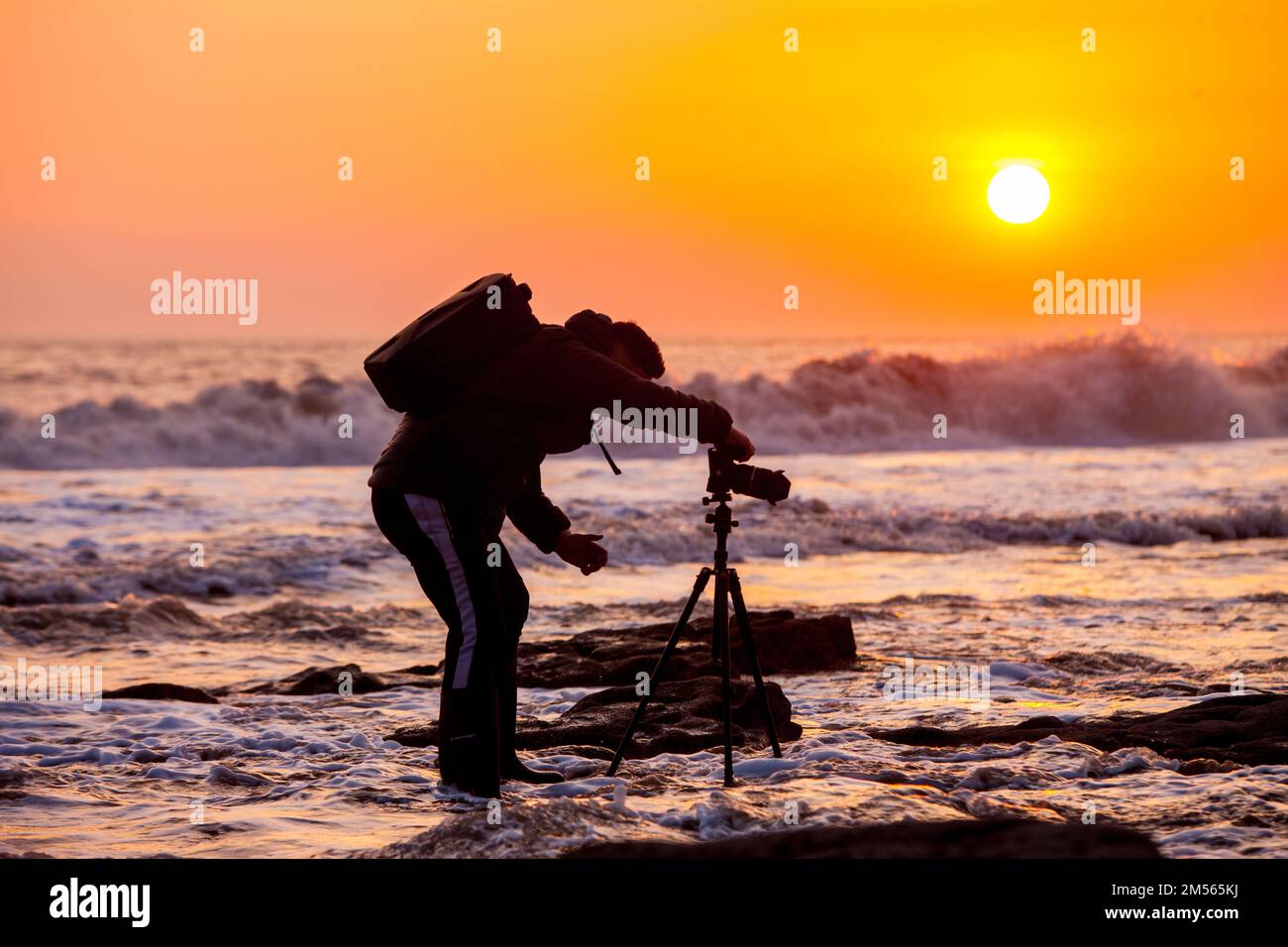 Silhouette,de,photographe,photographie,avec,appareil ,photo,sur,trépied,photographie,de,rochers,avec,vagues,et,réglage,soleil, coucher,de,soleil,dans,l'arrière-plan,Nash point,Vale de Glamourgan,pays de  Galles,Gallois Photo Stock - Alamy