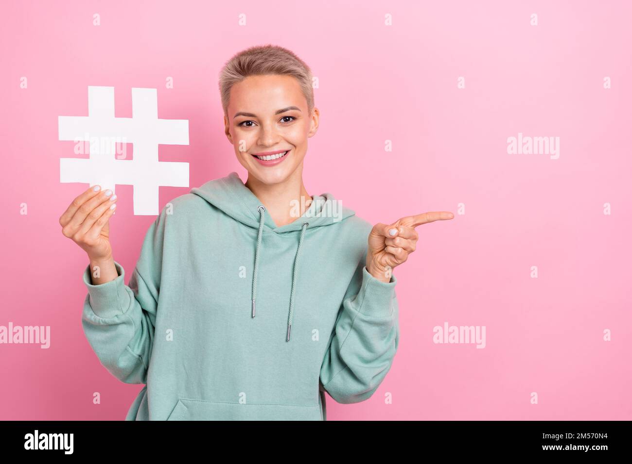 Photo portrait de la jeune femme attrayante tenir le hashtag point vide  espace habillé élégant kaki vêtements isolés sur fond de couleur rose Photo  Stock - Alamy