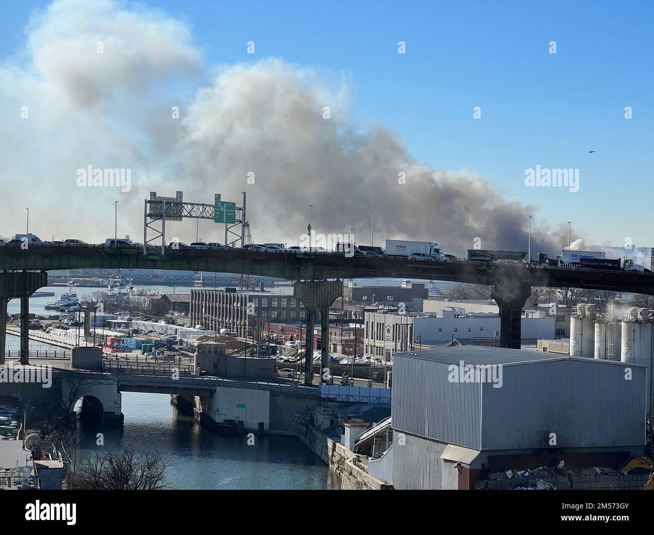 Le ciel rempli de fumée d'un incendie d'entrepôt domine l'autoroute Gowanus à Brooklyn, New York. Banque D'Images