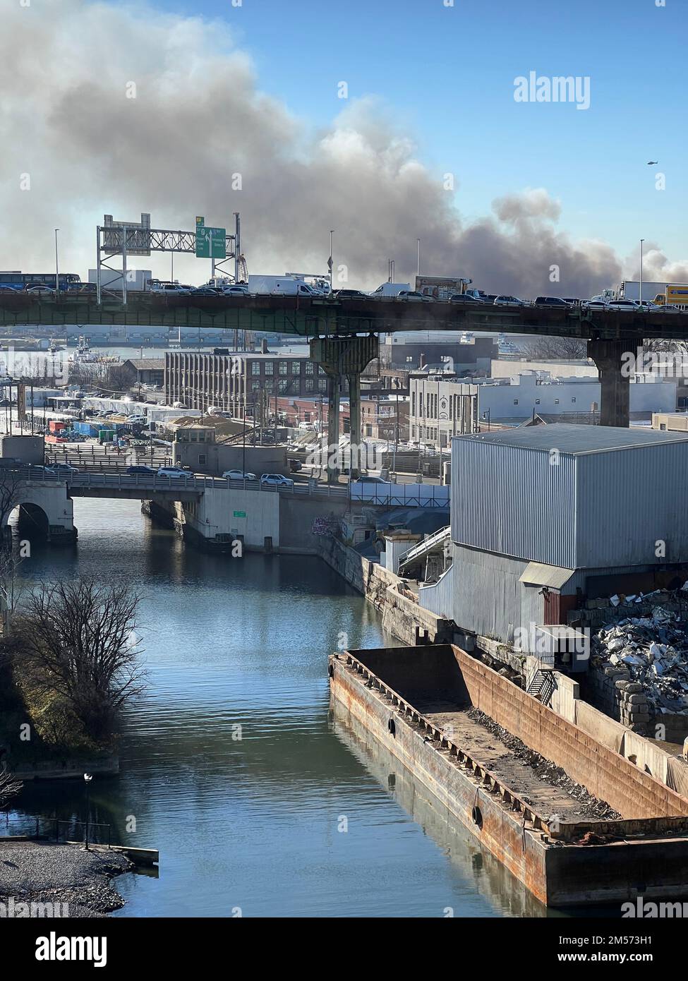 Le ciel rempli de fumée d'un incendie d'entrepôt domine l'autoroute Gowanus à Brooklyn, New York. Banque D'Images