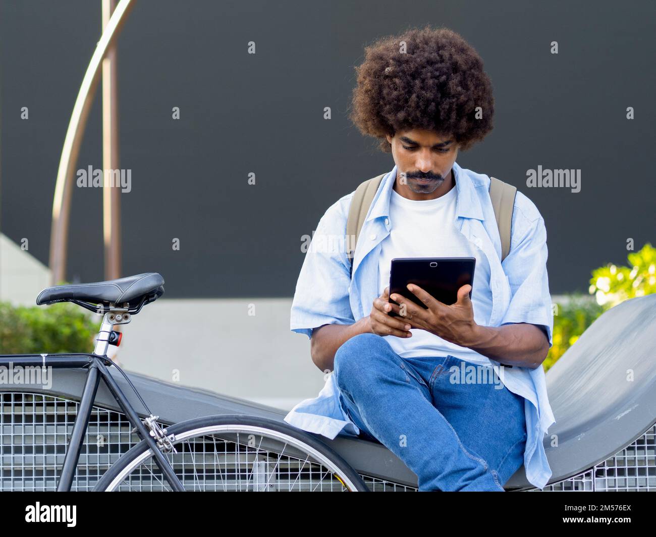 Jeune homme afro-américain entreprenant travaillant avec une tablette dans un quartier financier Banque D'Images