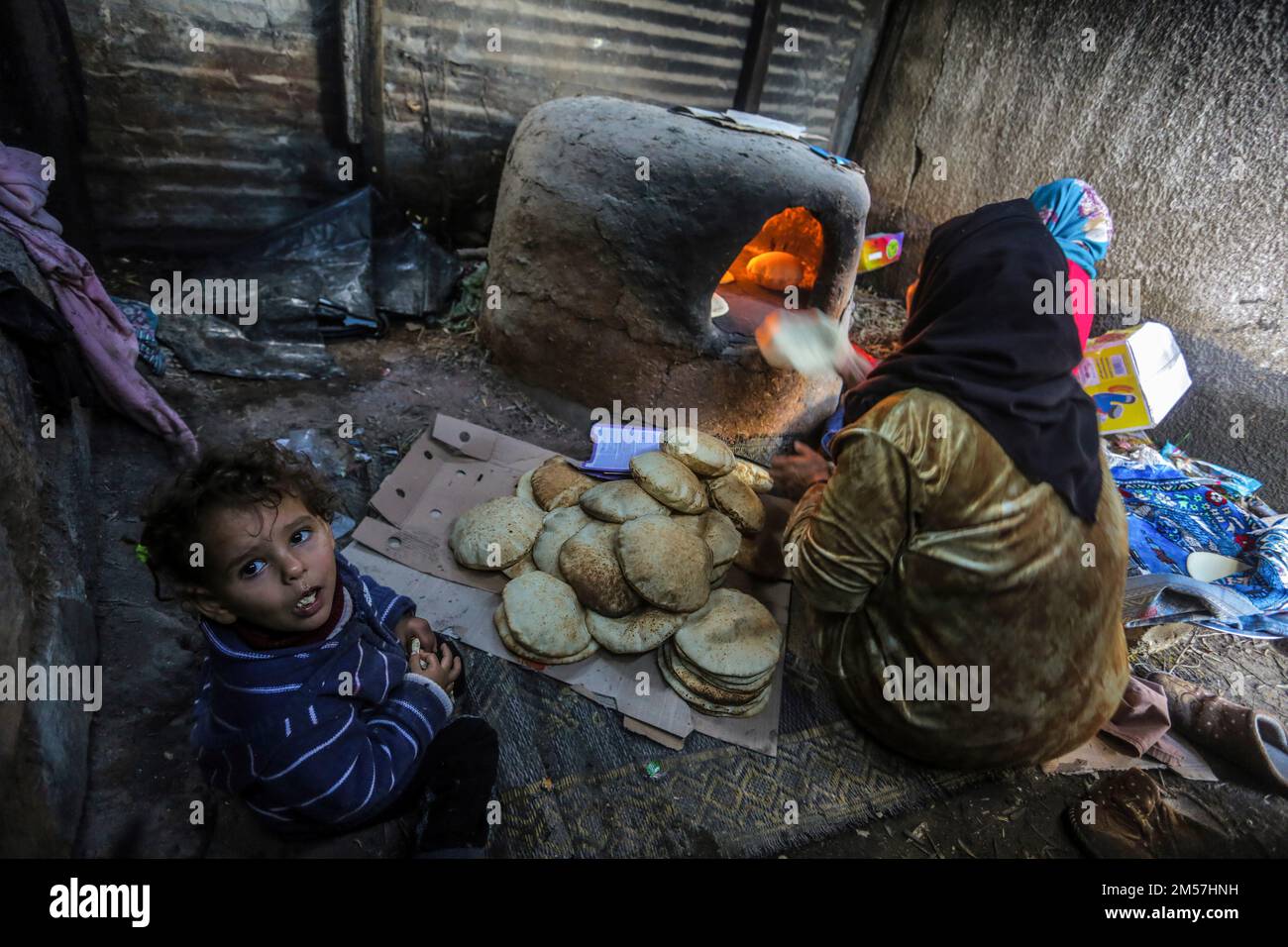 Gaza, Palestine. 26th décembre 2022. Les réfugiés palestiniens cuisent du pain de taboon dans leur foyer temporaire par temps froid dans le nord de la bande de Gaza. Les Palestiniens des bidonvilles de Beit Lahiya, dans le nord de la bande de Gaza, sont confrontés à des conditions difficiles à la lumière du temps froid. (Photo de Mahmoud Issa/SOPA Images/Sipa USA) crédit: SIPA USA/Alay Live News Banque D'Images