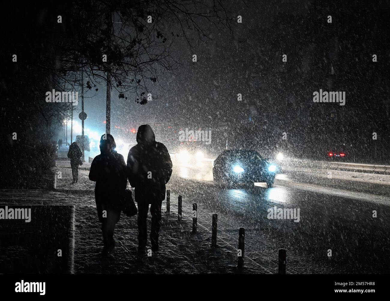 Kiev, Ukraine. 26th décembre 2022. Les gens descendent dans une rue sombre lors d'une forte chute de neige à Kiev. L'armée russe a mené des attaques massives de roquettes et de drones kamikaze sur les infrastructures énergétiques ukrainiennes. Après de graves dommages au réseau électrique dans de nombreuses villes d'Ukraine, la compagnie nationale d'électricité Ukrenergo a introduit des coupures d'électricité d'urgence et toutes les heures. Crédit : SOPA Images Limited/Alamy Live News Banque D'Images