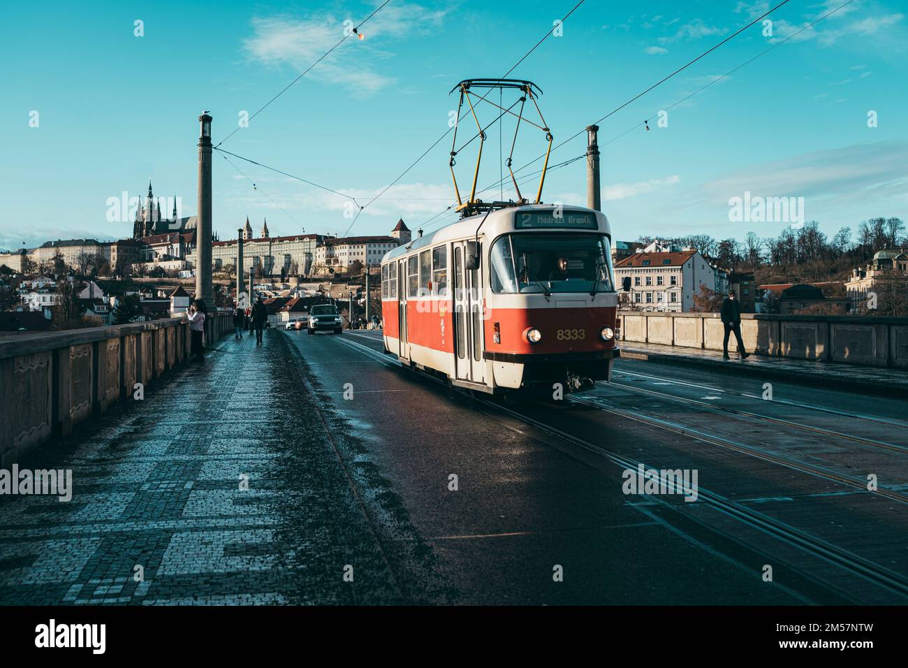 Un vieux tramway qui traverse le pont Manes à Prague, en République tchèque, sous un ciel bleu Banque D'Images