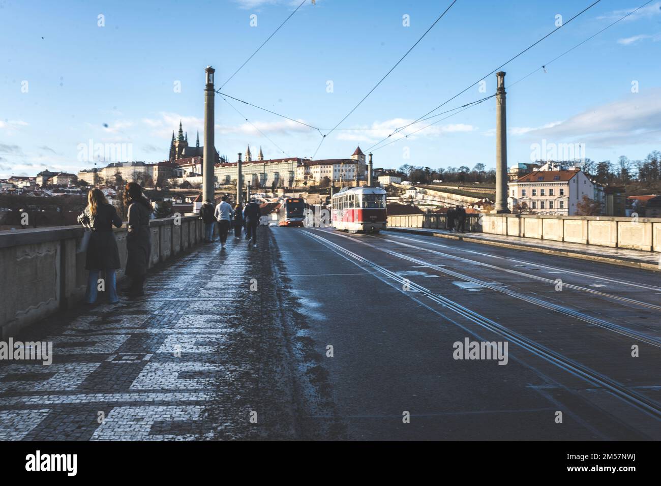 Un vieux tramway qui traverse le pont Manes à Prague, en République tchèque, sous un ciel bleu Banque D'Images