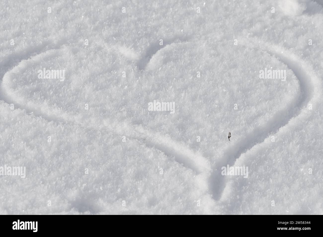 Coeur dessinant sur la neige blanche, l'hiver et l'amour fond Banque D'Images