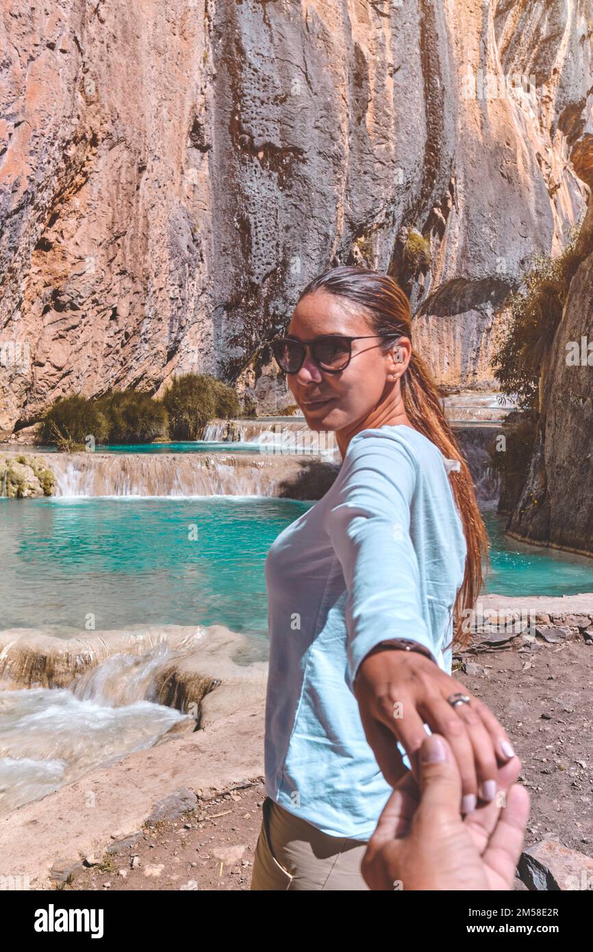 Gros plan Jeune femme tenant la main de l'homme tout en le conduisant sur la nature. Concept de voyage et d'amour Banque D'Images