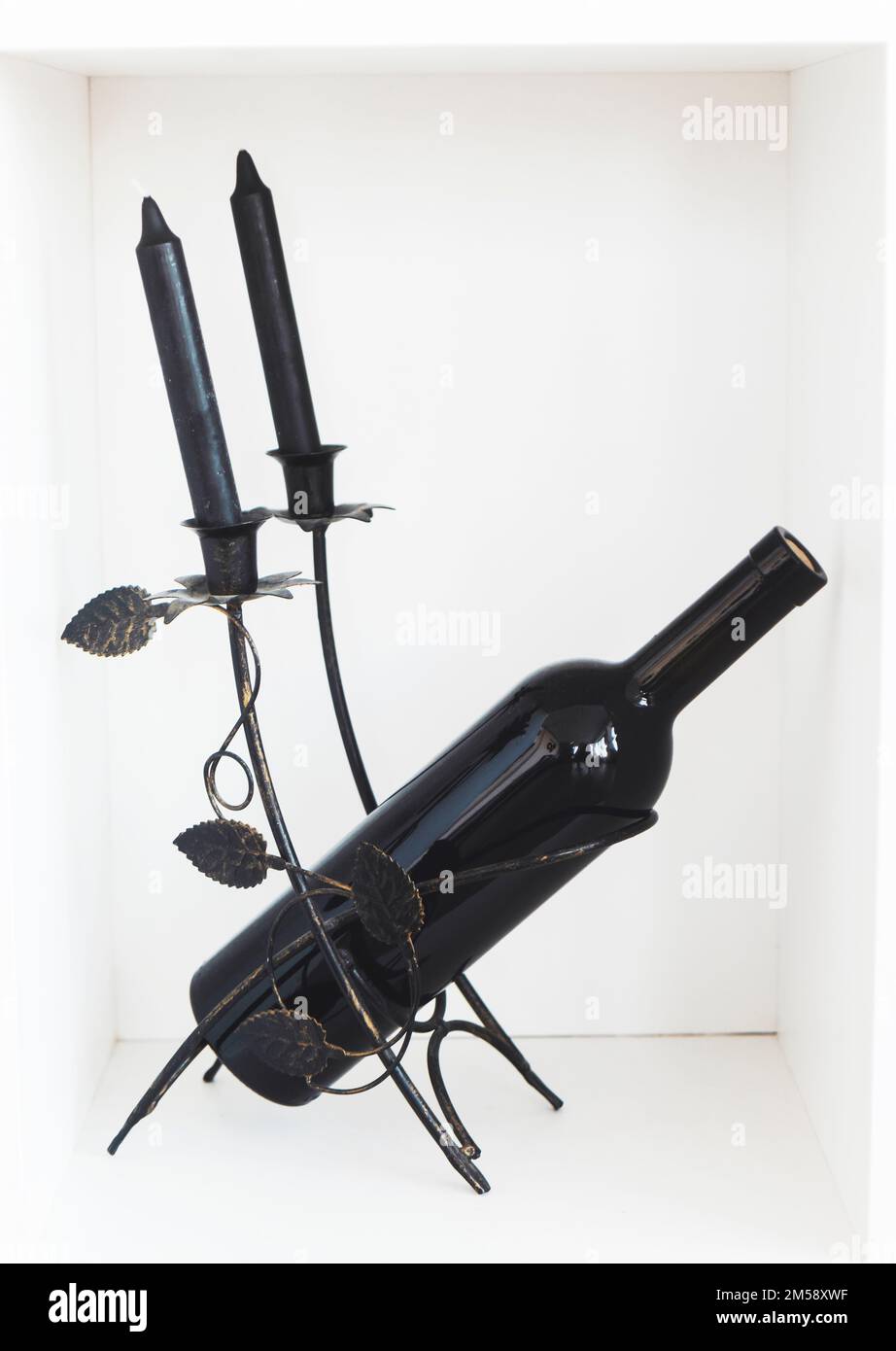 bouteille noire avec bougies noires sur fond blanc Banque D'Images