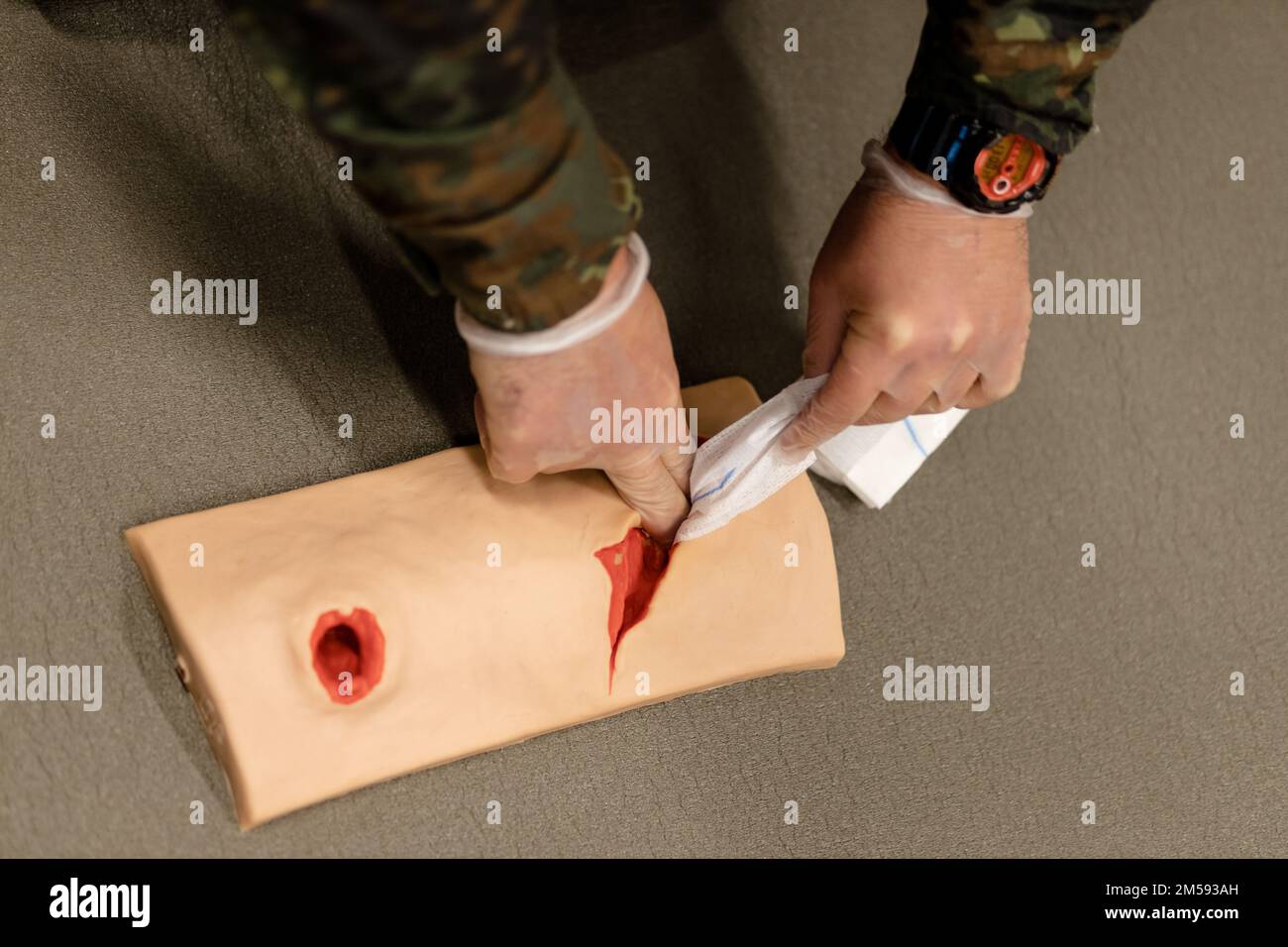 Une médic militaire pratique l'arrêt des saignements sur un mannequin blessé Banque D'Images