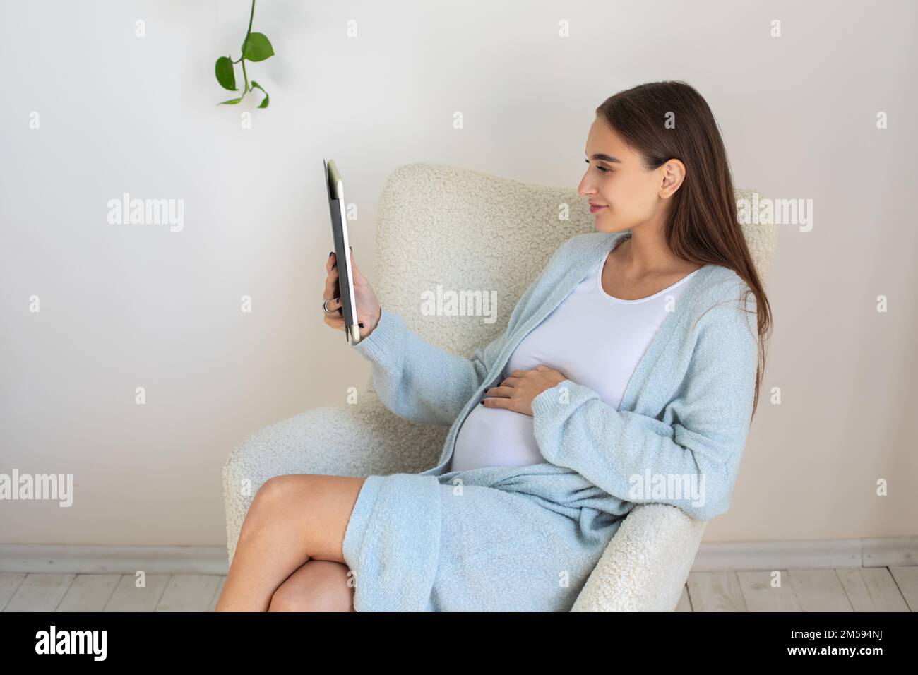 Jolie jeune femme enceinte avec un appareil à la main Banque D'Images