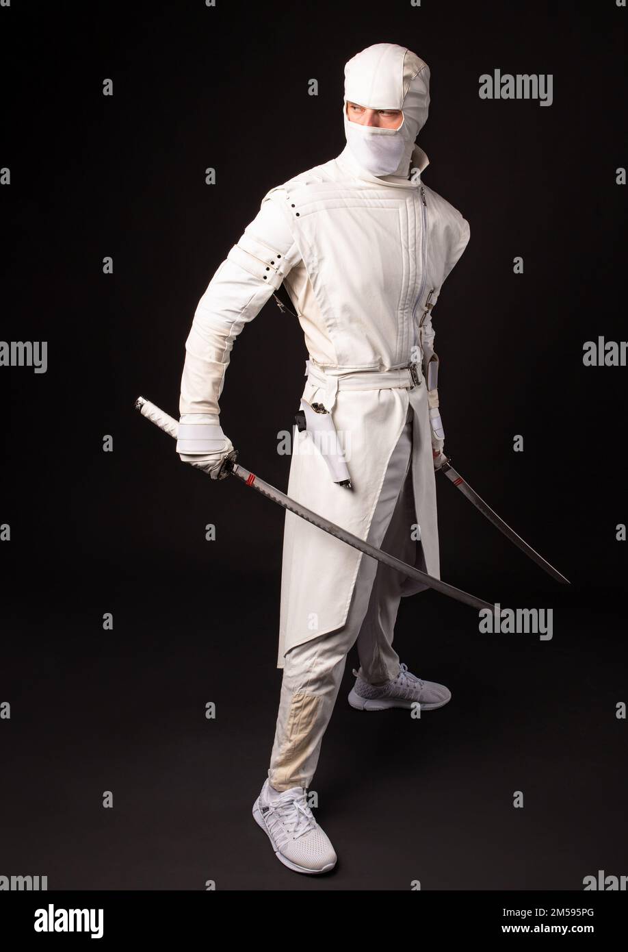 Combattez le ninja en posant deux épées sur un fond noir Banque D'Images