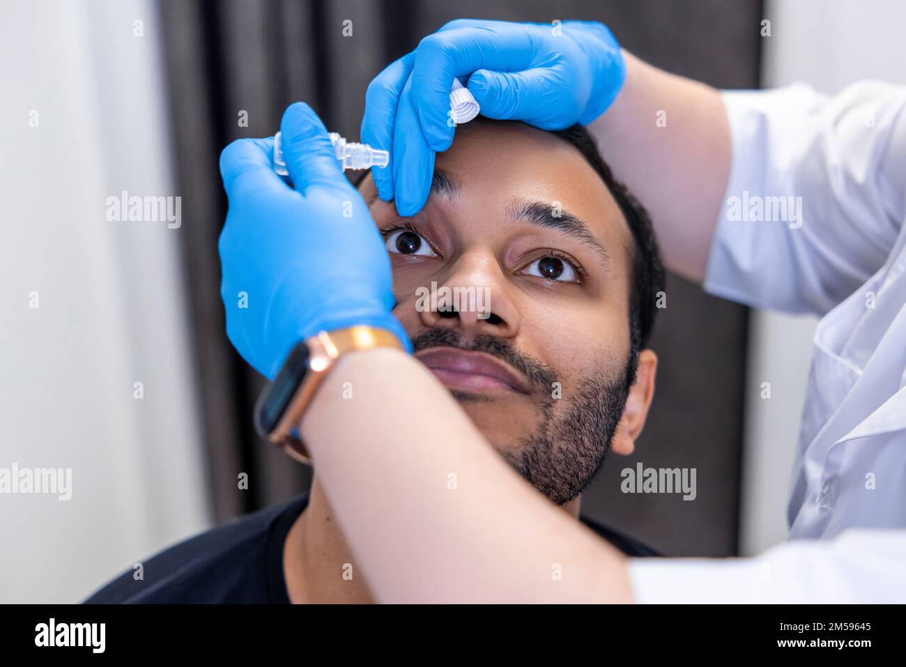 L'ophtalmologiste larde des gouttes oculaires aux yeux du patient Banque D'Images