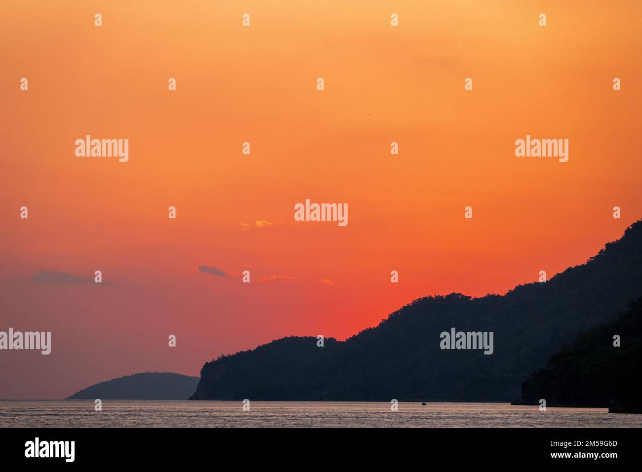 le soleil couchant sur les montagnes avec vue sur la mer. Banque D'Images