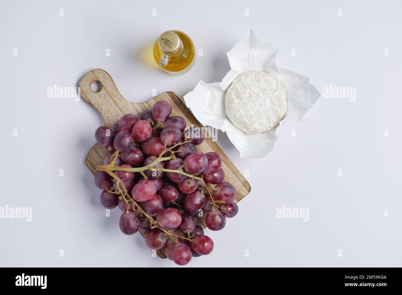 fromage de chèvre frais et fruits de raisin sur fond de bois. Banque D'Images