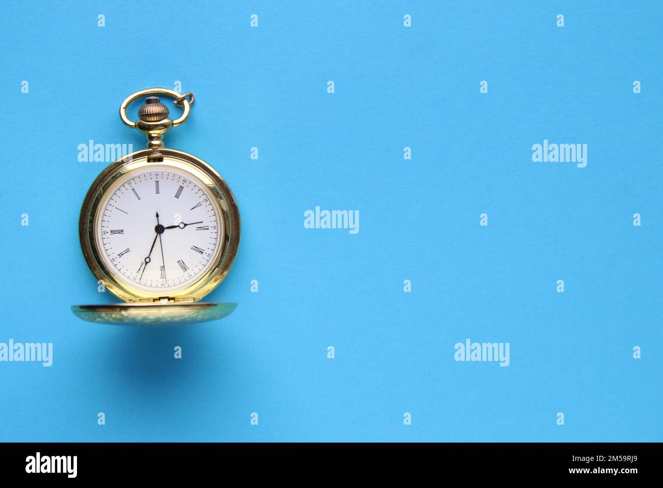 Montre de poche rétro dorée sur fond bleu. Banque D'Images