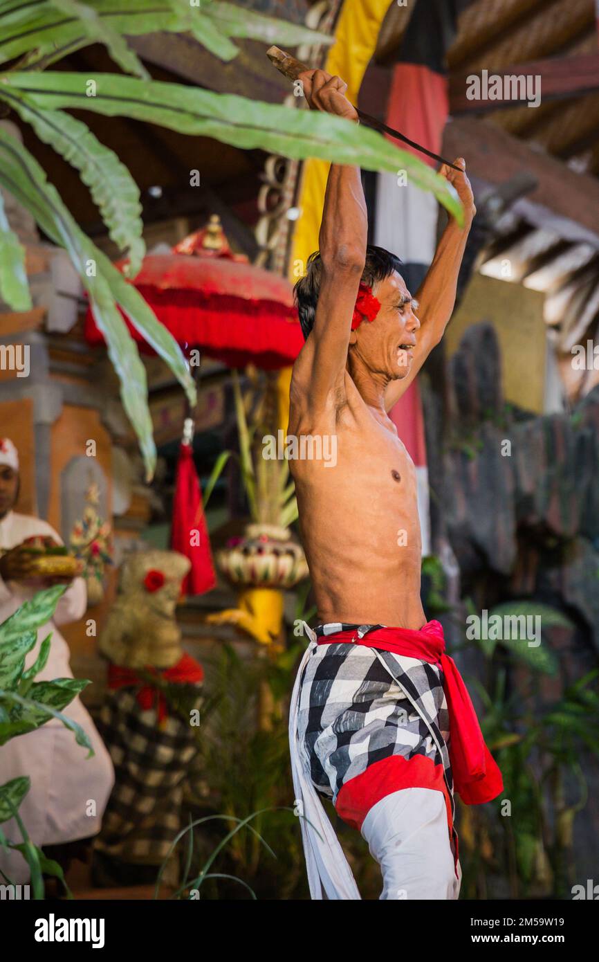 Bali - Indonésie - 10.22.2015: Un acteur de scène balinais masculin qui joue dans des vêtements traditionnels colorés, tenant un poignard Banque D'Images