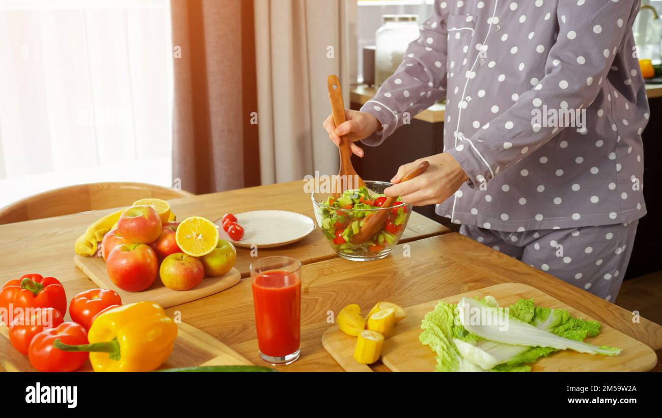 La femme au foyer mélange la salade de légumes et prend soin de la santé Banque D'Images