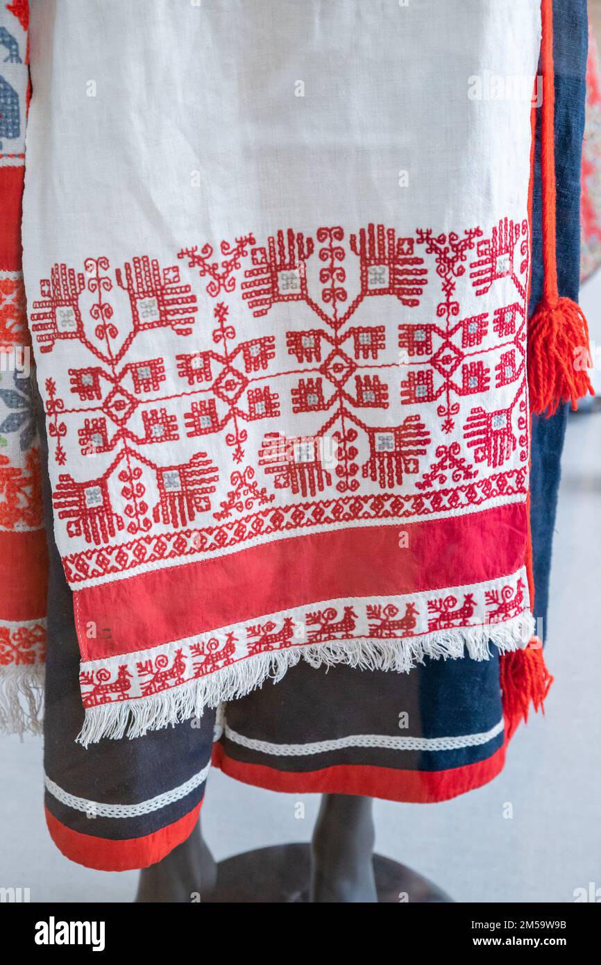 Broderie blanche traditionnelle ukrainienne rouge, serviette, tablier, robe chasuble. Gros plan. Banque D'Images