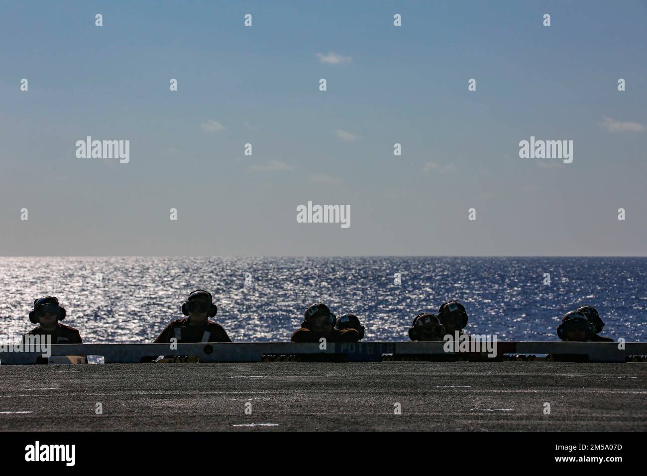 MER DES PHILIPPINES (13 FÉVRIER 2022) ÉTATS-UNIS Les marins de la Marine avec le porte-avions de la classe Nimitz USS Abraham Lincoln (CVN 72) observent les opérations de vol sur le pont de vol à l'appui de l'exercice Jungle Warfare 22 (JWX 22) à travers Okinawa, Japon, le 13 février 2022. JWX 22 est un exercice de formation sur le terrain à grande échelle axé sur l'exploitation des capacités intégrées des partenaires conjoints et alliés pour renforcer la sensibilisation, les manœuvres et les incendies de tous les domaines dans un environnement maritime distribué. Banque D'Images