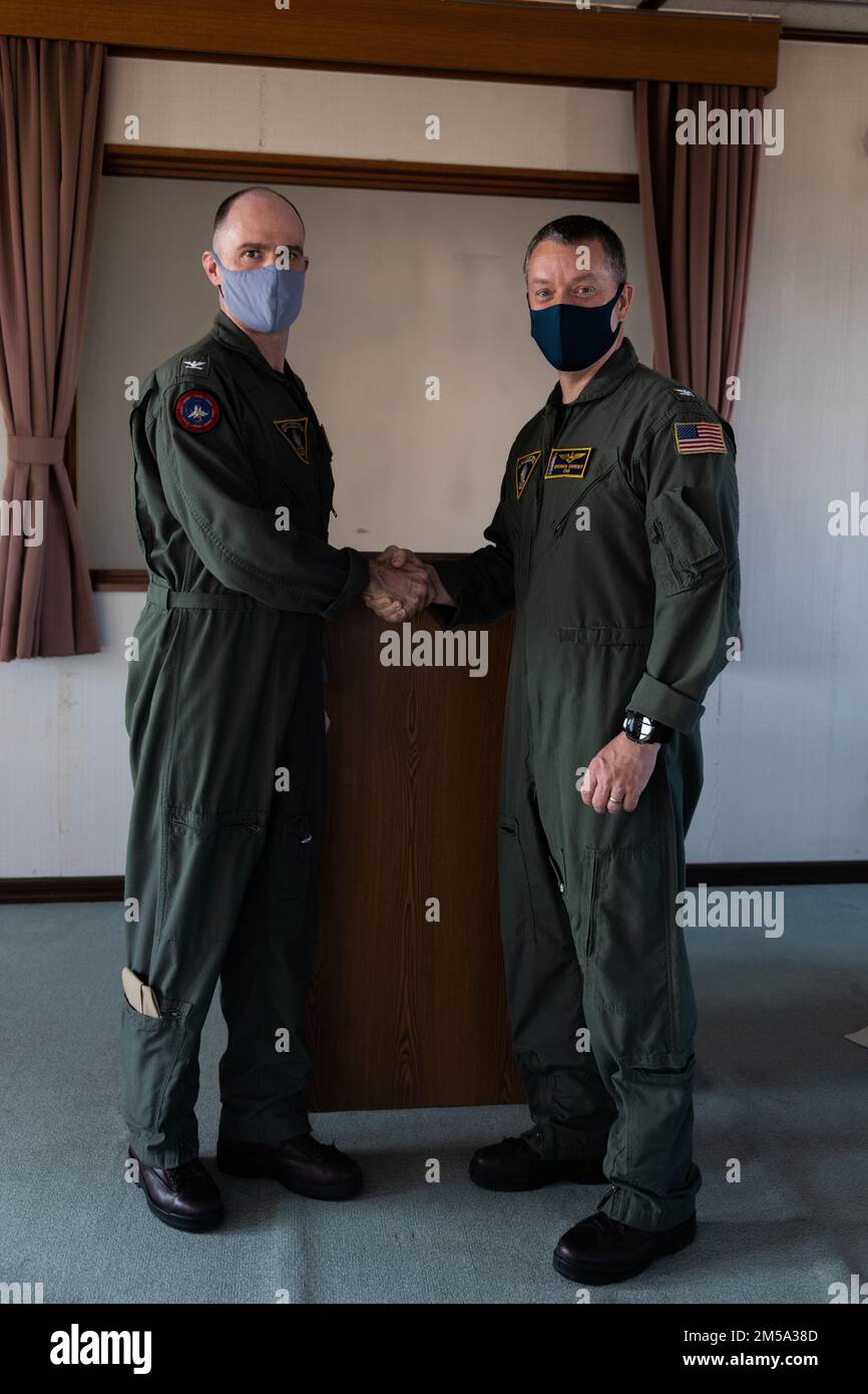 ÉTATS-UNIS Le capitaine de la Marine, Adrian Calder, à gauche, commandant en exercice de l'escadre aérienne Carrier (CVW) 5, félicite le capitaine Michael Sweeney, le commandant venant en poste, lors d'une cérémonie de changement de commandement à la station aérienne du corps des Marines Iwakuni, le 14 février 2022. Une cérémonie de changement de commandement est une tradition qui a été honorée dans le temps et qui signifie officiellement le transfert de l'autorité d'un commandant à l'autre. Le CVW-5 est déployé vers la station aérienne afin d'assurer la sécurité et la stabilité dans l'ensemble de l'Indo-Pacifique. Banque D'Images