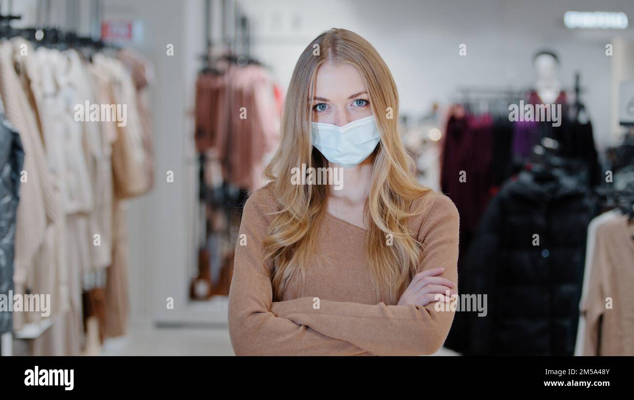 Réussi blonde jeune femme vendeur consultant fille habillement magasin propriétaire petite entreprise dame acheteur client dans le masque médical debout dans le centre commercial Banque D'Images