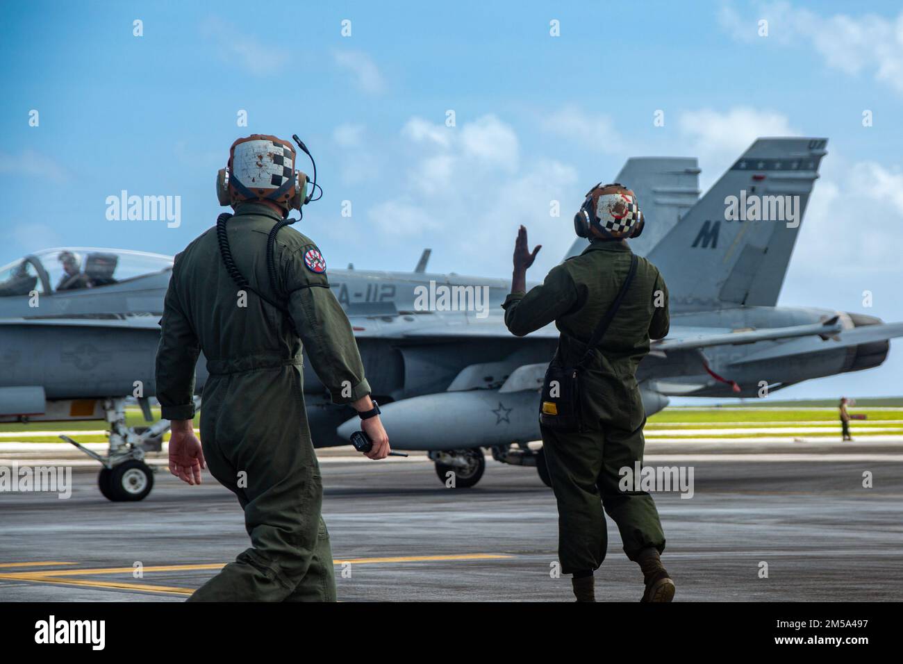 ÉTATS-UNIS Le Sgt Devon Csendes (à gauche), un chef de division de ligne de puissance de l'escadron d'attaque de chasseurs marins 112, et le Cpl. Trevor Young, mécanicien de ligne de puissance de VMFA-112, guident un avion F/A-18C Hornet pendant le COPE North 2022 à la base aérienne d'Andersen, Guam, le 14 février 2022. Cope North est un exercice multinational mené chaque année à la base aérienne d'Andersen qui améliore les relations des États-Unis avec nos alliés et partenaires régionaux en favorisant l'échange d'informations et en affinant les tactiques partagées pour renforcer le soutien mutuel à la sécurité régionale. Banque D'Images