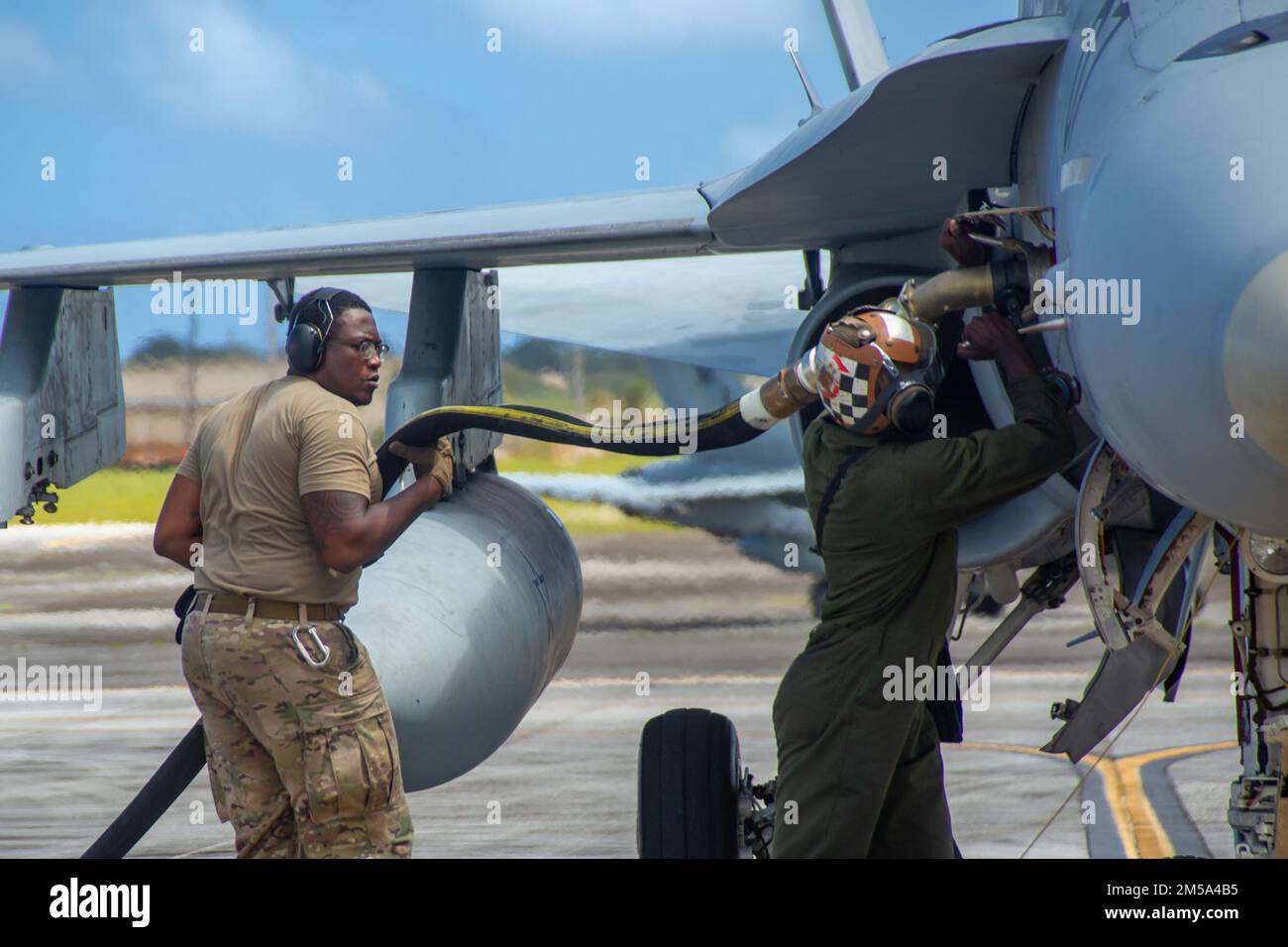 Sergent d'état-major de la Force aérienne des États-Unis Christopher Broome (à gauche), superviseur de l'équipement de soutien à la mobilité du carburant au 40th e Escadron de transport aérien, et Cpl lance du corps des Marines des États-Unis. Trevor Young, mécanicien de ligne de puissance de l'escadron d'attaque de chasseurs marins 112, ravitailler un avion F/A-18C Hornet au cours du COPE North 2022 à la base aérienne d'Andersen, Guam, le 14 février 2022. Cope North est un exercice multinational mené chaque année à l'AFB d'Andersen qui améliore les relations des États-Unis avec nos alliés et partenaires régionaux en favorisant l'échange d'informations et en affinant les tactiques partagées pour renforcer le soutien mutuel de la secu régionale Banque D'Images