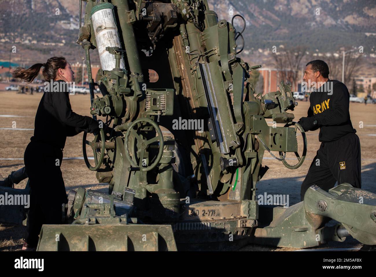 2nd Lt. Margaret Go et SPC. Christopher Chin, tous deux affectés à l'artillerie de la division d'infanterie 4th (DIVARTY), ont fait tourner les roues d'un obusier tracté M777 de 155mm pendant le défi DIVARTY Ivy Gunners Howitzer M777, le 16 février 2022, à Pershing Field, fort Carson, Colorado. Les concurrents ont travaillé deux à la fois pour actionner les roues afin de relever et d'abaisser complètement le canon de la grande arme. Banque D'Images