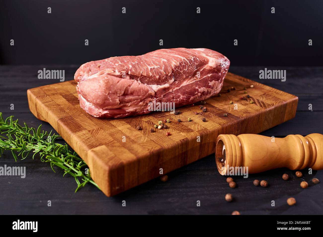 Steak de bœuf frais sur planche à découper en bois, vue du dessus. Servi sur fond noir. Bannière de conception Web avec espace de copie. Aliments biologiques frais et sains Banque D'Images