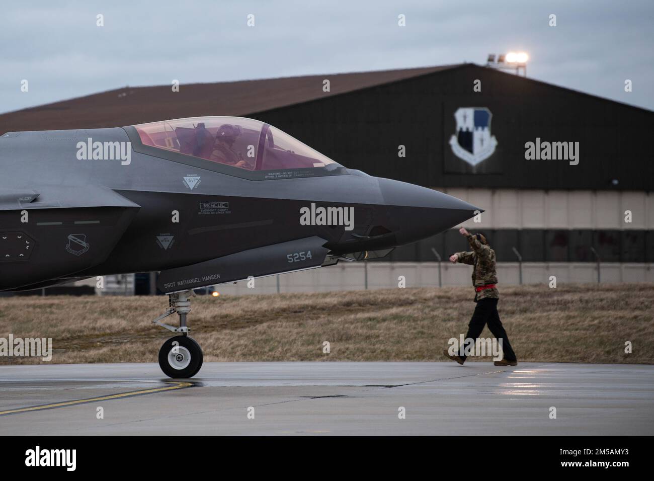 A ÉTATS-UNIS L'agent d'entretien de l'avion de la Force aérienne envoie des signaux à un Le pilote de la Force aérienne F-35A Lightning II du 34th Fighter Squadron de la base aérienne de Hill, Utah, après son arrivée à la base aérienne de Spangdahlem, en Allemagne, le 16 février 2022. L’équipe F-35 s’est déployée à la base aérienne de Spangdahlem pour renforcer la position de défense collective de l’OTAN et renforcer les capacités des partenaires et alliés régionaux. Banque D'Images