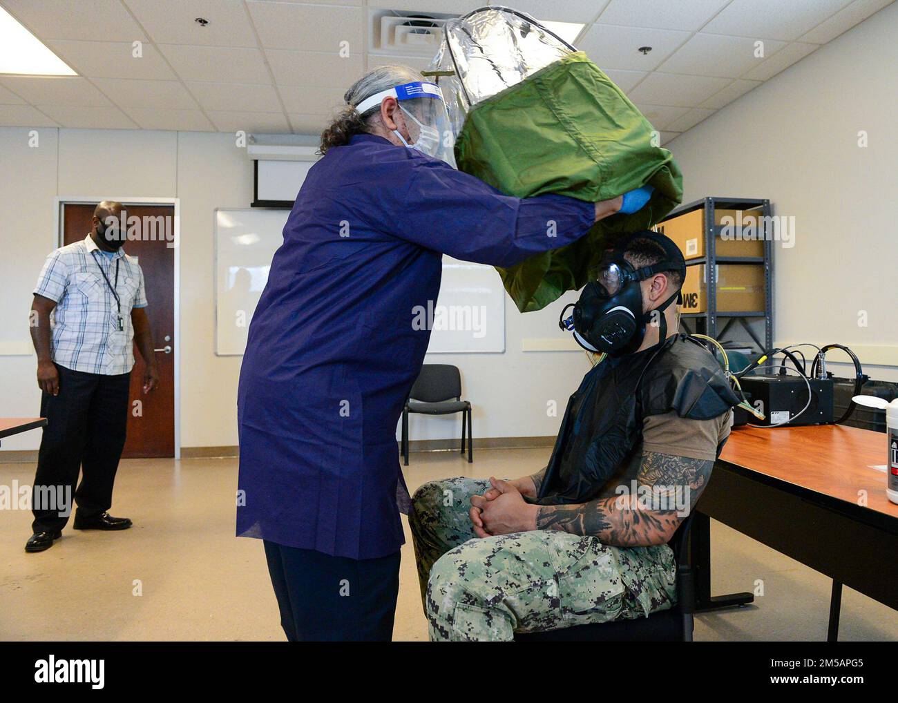 FORT WORTH, Texas (16 février 2022) - le testeur de fuite de masque de service commun Arnie Perez, au centre, effectue un test d'ajustement du masque à gaz M-50 pour la Réserve navale Yeoman 1st classe Andre Polk, affecté au Centre de réserve navale de New York, à Navy Reserve Region Readiness et mobilisation Command fort Worth (REDCOM FW), en préparation de la mobilisation prévue de Polk au Qatar. Un traitement de mobilisation de réserve sélectionné pour Polk et d'autres marins a eu lieu au cours d'un événement de mobilisation adaptative au REDCOM FW 14-18 février. L'événement a été observé par des évaluateurs du Expeditionary combat Readiness Centre, Banque D'Images