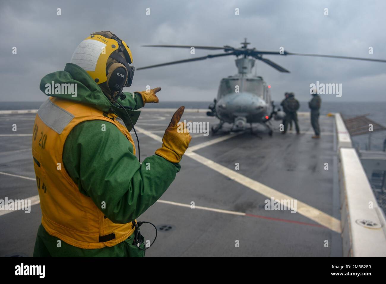 MER DES PHILIPPINES (17 février 2022) Aviation Boatswain's Mate (Handling) 2nd classe John Montano, d'Oakdale (Californie), affecté au quai de transport amphibie USS Green Bay (LPD 20), signale un hélicoptère UH-1Y Huey du Marine Medium TIltrotor Squadron (VMM) 265 sur le pont de vol. Green Bay, qui fait partie du groupe de grève expéditionnaire 7, ainsi que de l'unité expéditionnaire maritime (UMM) de 31st, opère dans la zone de responsabilité de la flotte américaine 7th afin d'améliorer l'interopérabilité avec les alliés et les partenaires et de servir de force de réaction prête à l'emploi pour défendre la paix et la stabilité dans la région Indo-Pacifique. Banque D'Images