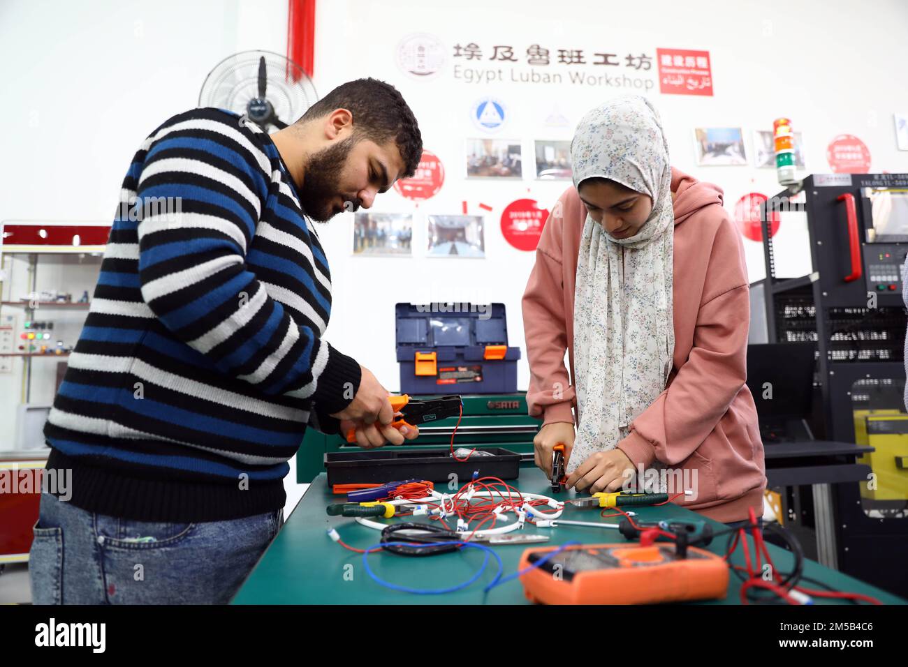 Le Caire, Égypte. 21st décembre 2022. Les stagiaires apprennent la connexion de circuits dans la zone de formation à l'installation de la commande numérique par ordinateur (CNC) de l'atelier Luban à l'Université Ain Shams au Caire (Egypte), le 21 décembre 2022. Lors d'un atelier à l'Université Ain Shams au Caire, un certain nombre d'étudiants en ingénierie ont été formés à l'utilisation de G-code, un langage de programmation, pour créer un contrôle automatisé d'une machine. L'atelier, également connu sous le nom de Centre Luban Egypt pour la formation professionnelle, est l'un des nombreux exemples de la coopération en matière d'éducation entre la Chine et l'Égypte. Credit: Ahmed Gomaa/Xinhua/Alamy Live News Banque D'Images