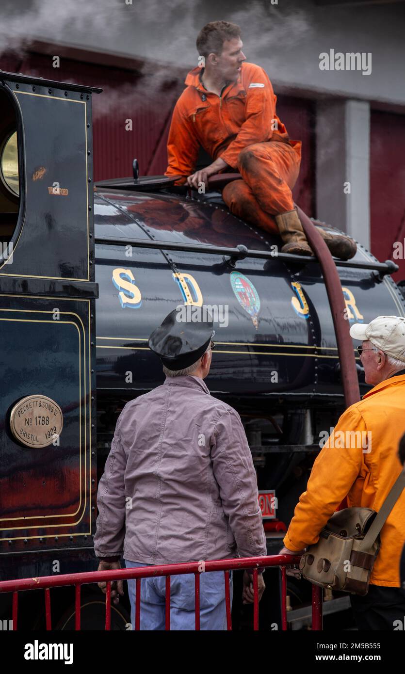 les mécaniciens réparent une vieille locomotive à vapeur dans un dépôt Banque D'Images