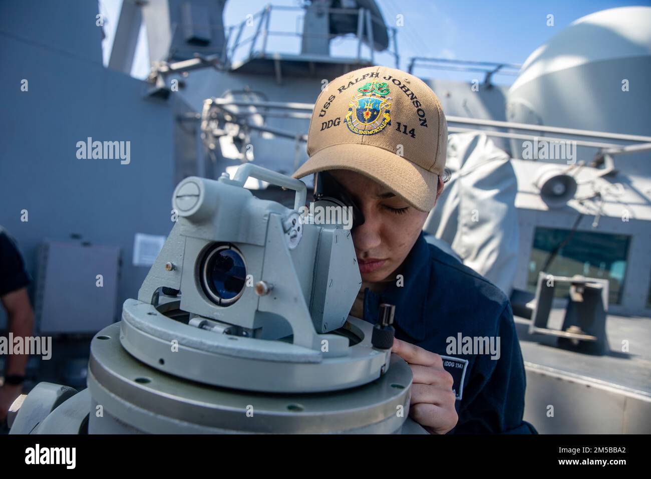 MER DE CHINE DU SUD (18,2022 février) Spécialiste des opérations le marin recrute Alayis Vicens, de Lorain, Ohio, cherche des contacts de surface sur l'aile du pont, alors que le destroyer à missiles guidés de classe Arleigh Burke USS Ralph Johnson (DDG 114) effectue des opérations courantes en cours. Ralph Johnson est déployé à l'avant-plan dans la zone d'opérations de la flotte américaine 7th afin de soutenir un Indo-Pacific libre et ouvert. Banque D'Images