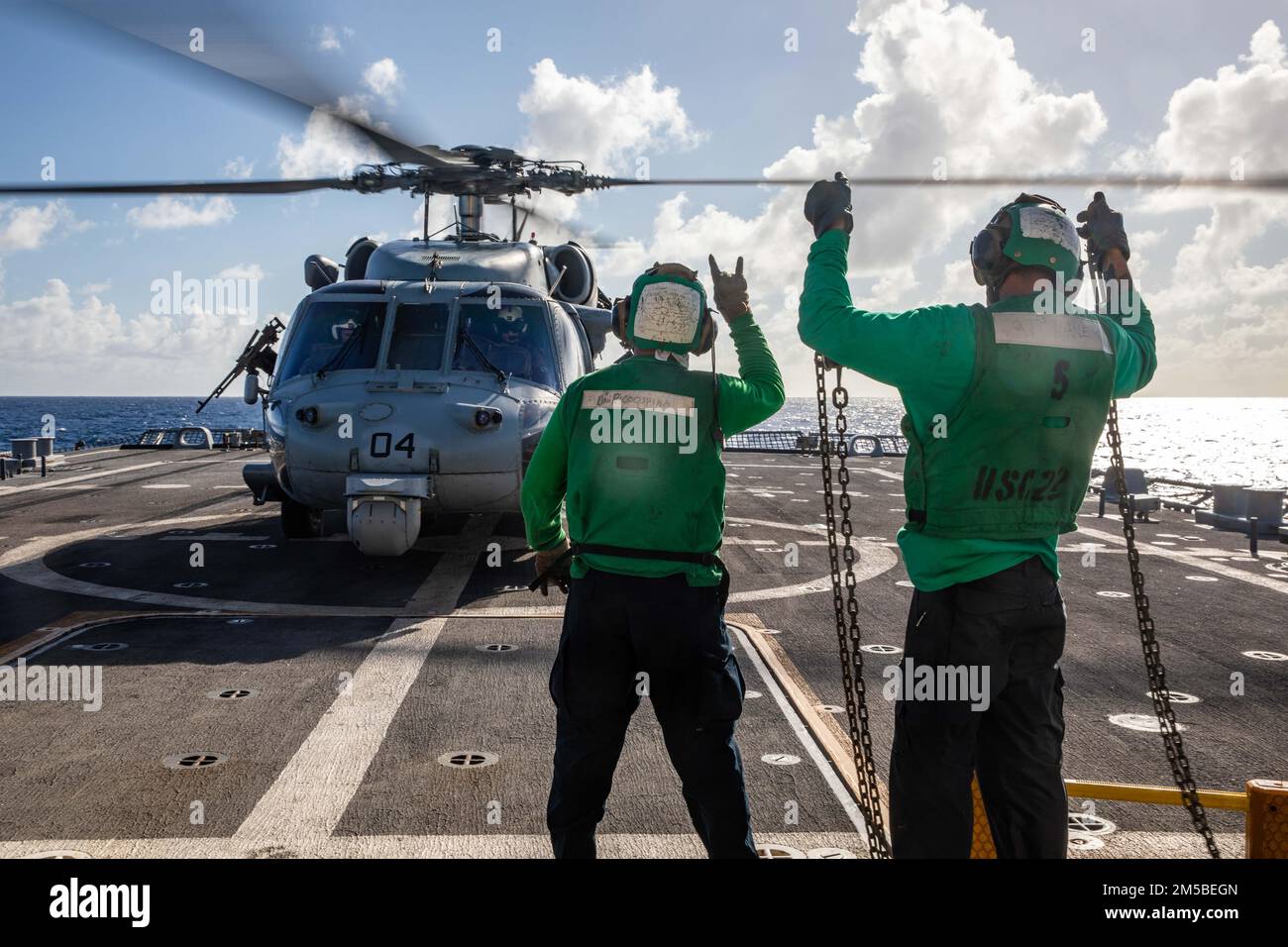 220221-N-HD110-1028 MER DES CARAÏBES - (le 21 février 2022) -- Airman Felix Ricoospina, compagnon de machiniste de l'aviation, signale aux pilotes un hélicoptère MH-60s Sea Hawk, attaché aux chevaliers de mer de l'Escadron de combat en mer (HSC) 22, détachement 5, Que des cales et des chaînes ont été retirées de l'avion avant le décollage sur le pont de vol du navire de combat littoral Freedom-variant USS Milwaukee (LCS 5) lors d'un exercice d'utilisation de la force aérienne (AUF), le 21 février 2022. Milwaukee est déployé dans la zone d’opérations de la flotte américaine 4th pour soutenir la mission de la Force opérationnelle interagence conjointe Sud, qui en Banque D'Images