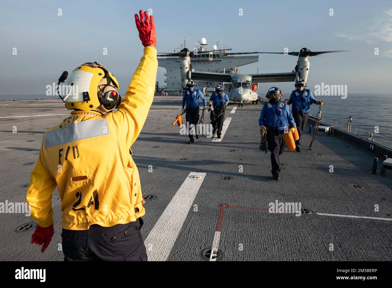 220221-N-TI693-2174 MÉDITERRANÉE- (21 février 2022) Aviation Boatswain's Mate (Handling) 2nd classe Kieara Dexter, avant, d'Opelika, Alabama, Signale au pilote d'un MV-22 Osprey que l'équipe de la cale et de la chaîne s'éloigne de l'avion pendant les opérations de pont de vol à bord de la base maritime expéditionnaire USS Hershel 'Woody' Williams (ESB 4), le 21 février 2022. Hershel 'Woody' Williams est en cours de déploiement aux États-Unis Sixième zone d'exploitation de la flotte à l'appui des intérêts nationaux et de la sécurité des États-Unis en Europe et en Afrique. Banque D'Images