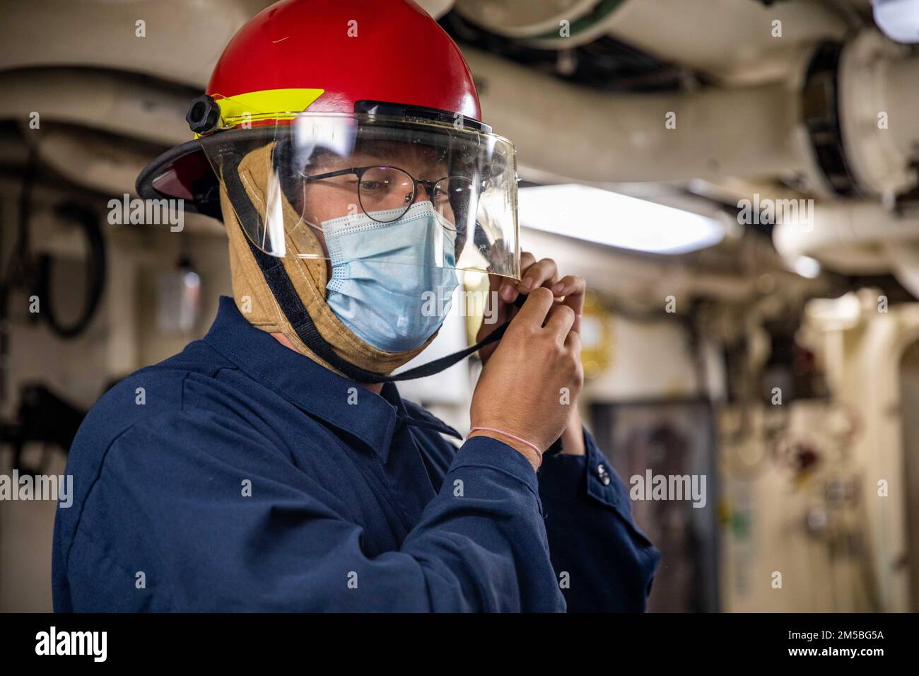 220222-N-HD110-1009 MER DES CARAÏBES - (22 février 2022) -- technicien en systèmes d'information 2nd classe Slade Dubberly met un casque de lutte contre les incendies lors d'un exercice d'équipe de contrôle des dommages à bord du navire de combat littoral Freedom-variant USS Milwaukee (LCS 5), 22 février 2022. Milwaukee est déployée dans la zone d’opérations de la flotte américaine 4th pour appuyer la mission de la Force opérationnelle interagences conjointe Sud, qui comprend des missions de lutte contre le trafic de drogues illicites dans les Caraïbes et le Pacifique oriental. Banque D'Images