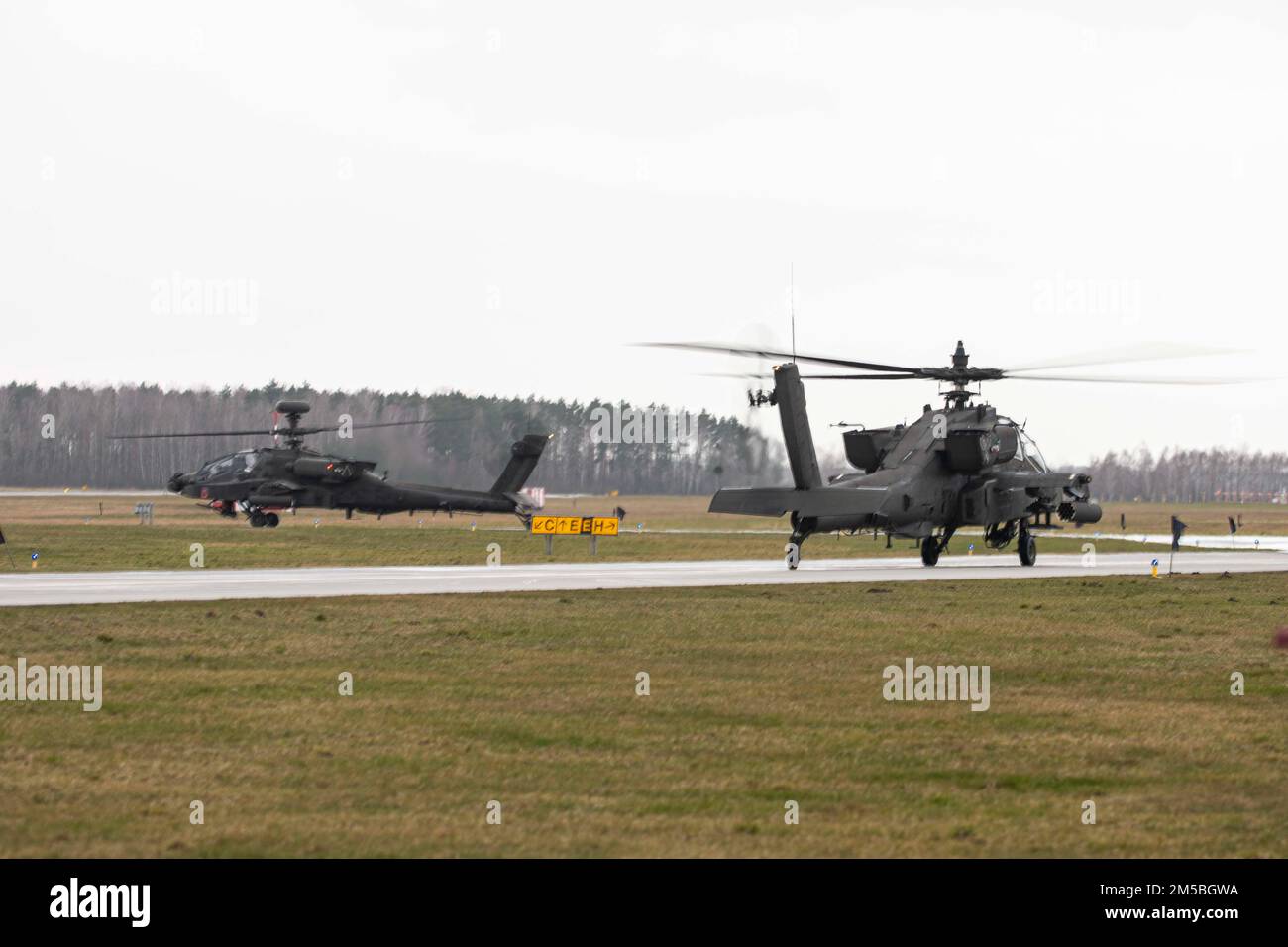 Deux États-Unis Armée AH64 hélicoptères Apache-Delta appartenant à la 12th combat Aviation Brigade, 1-3 Attack Battalion, Katterbach Allemagne, taxi pour décoller de la base aérienne de Łask pour participer à l'exercice Sabre Strike 22 en Europe de l'est, à Łask Air Basel Pologne, 22 février 2022. L'exercice Sabre Strike est un exercice intégré d'entraînement sur le terrain qui se déroule chaque année en Estonie, en Lettonie, en Lituanie et en Pologne, augmentant la capacité opérationnelle conjointe et renforçant l'alliance de l'OTAN. Banque D'Images