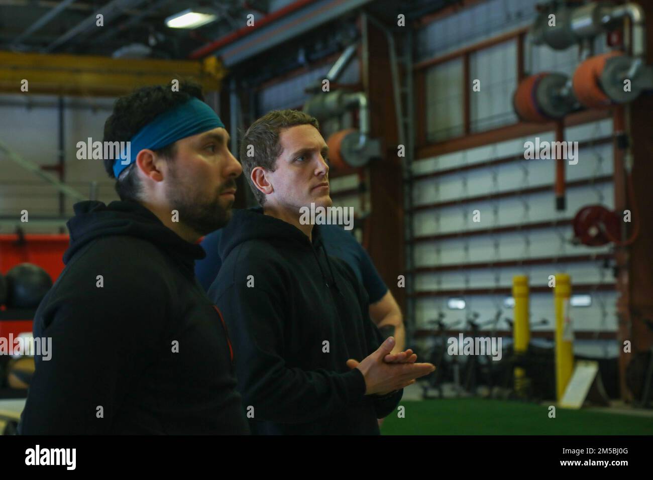 Ben Rosner et Craig Doran, entraîneurs de force et de conditionnement au sein de l'équipe holistique de santé et de conditionnement physique de la Brigade de soutien de la Mountain Division 10th, s'adressera à un groupe de soldats, le 22 février 2022, lors d'un cours de prolongation de l'entraînement physique H2F à fort Drum, New York. Pendant le cours PT Extender, les entraîneurs de l'équipe de H2F enseignent aux soldats les techniques d'exercice appropriées et la façon de mettre en œuvre divers exercices de force et de conditionnement dans les sessions PT pour augmenter la préparation physique tout en réduisant les blessures. Banque D'Images