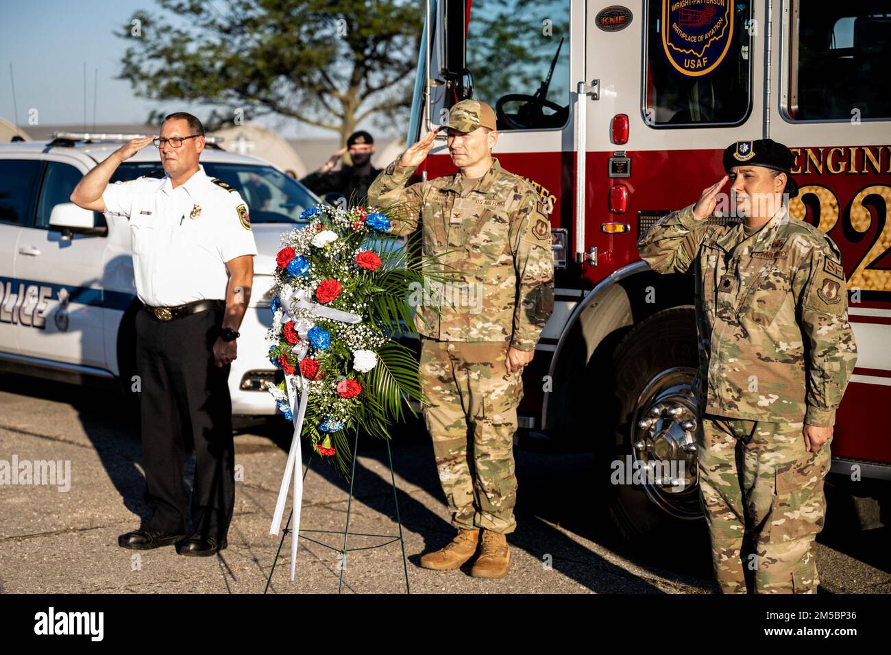 De gauche à droite : le chef des pompiers Jacob King, 788th e Escadron de génie civil; le colonel Dale Harrell, commandant du Groupe médical 88th; et le lieutenant-colonel Nicole Schatz, commandant du 88th e Escadron des forces de sécurité, saluent pendant un moment de silence après avoir déposé une couronne le 9 septembre 2022 à la base aérienne Wright-Patterson, Ohio. La pose de couronne faisait partie du souvenir de 9/11 qui comprenait une course de commémoration. Banque D'Images