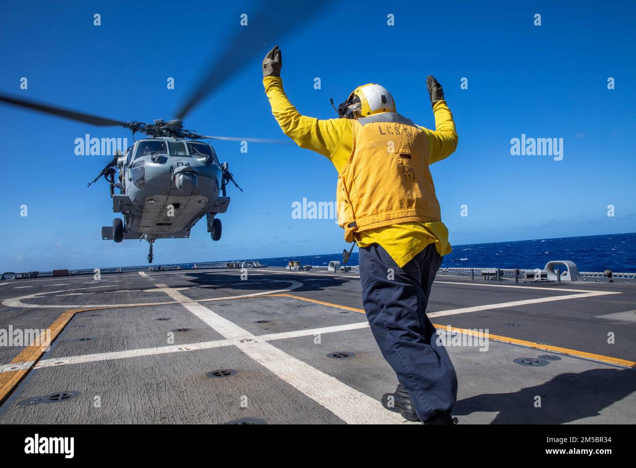 220224-N-HD110-1046 MER DES CARAÏBES - (24 FÉVRIER 2022) -- Le compagnon de Boatswain 2nd classe George APAV signale aux pilotes d’un hélicoptère MH-60s Sea Hawk attaché aux “Chevaliers de mer” du détachement 5 de l’Escadron de combat de la mer (HSC) 22, de décoller du pont de vol du navire de combat littoral Freedom-variant USS Milwaukee (LCS 5), 24 février 2022. Milwaukee est déployée dans la zone d’opérations de la flotte américaine 4th pour appuyer la mission de la Force opérationnelle interagences conjointe Sud, qui comprend des missions de lutte contre le trafic de drogues illicites dans les Caraïbes et le Pacifique oriental. Banque D'Images