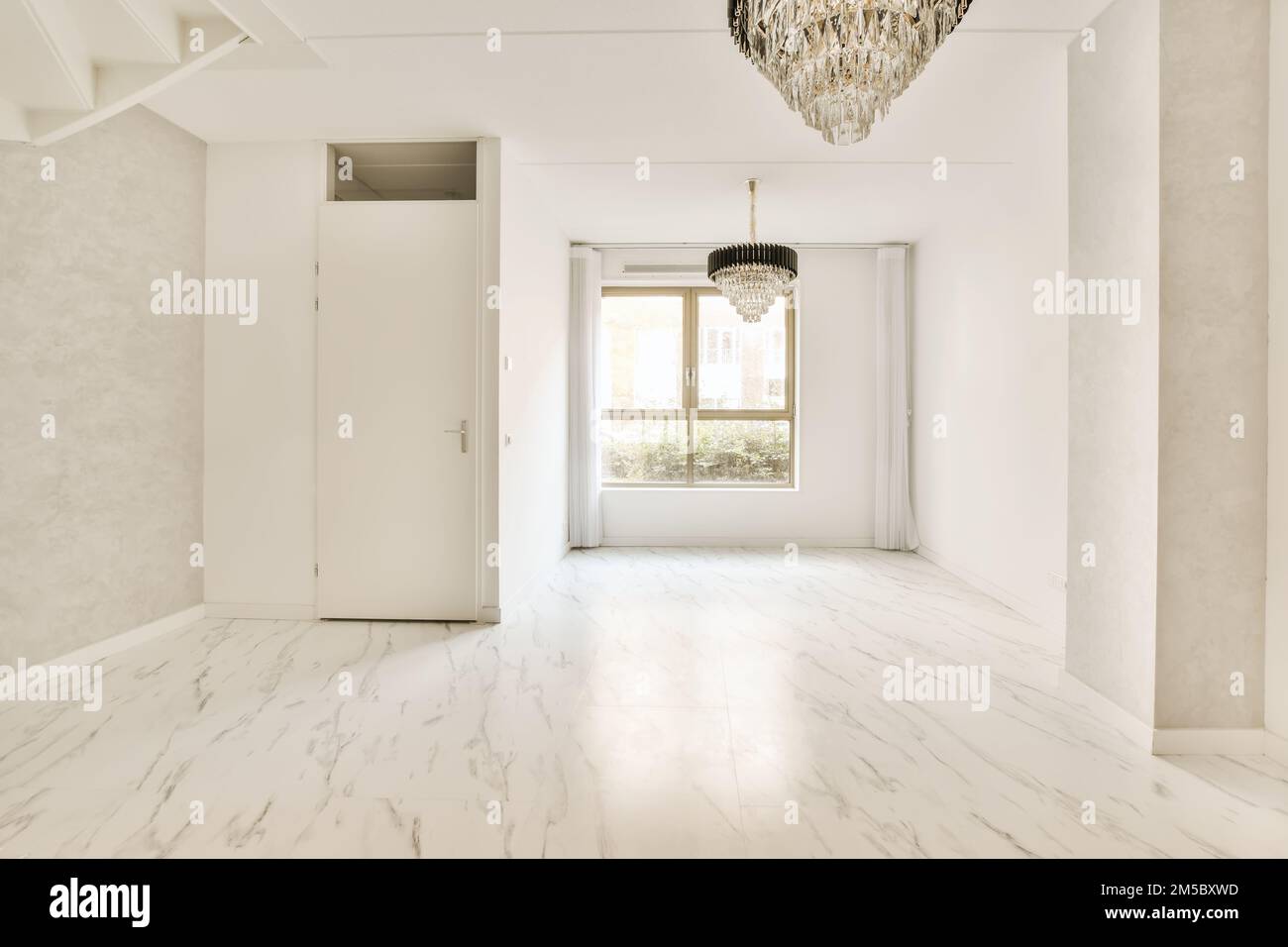 une chambre vide avec un sol en marbre blanc et un luminaire suspendu au plafond au-dessus de la porte Banque D'Images