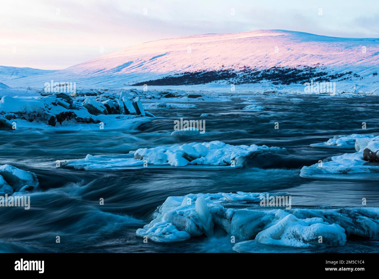 Blocs de glace dans la rivière Skalfandafljot à l'aube, près de la cascade Godafoss, paysage enneigé, nord de l'Islande Eyestra, Islande Banque D'Images