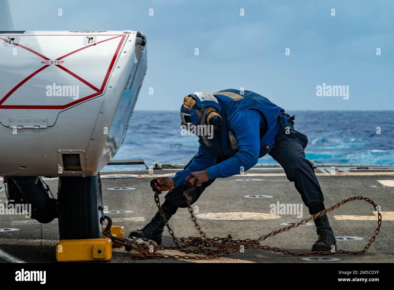 OCÉAN PACIFIQUE (1 mars 2022) le Matelot de 1re classe de Boatswain, Alvin Moe, de New York, retire des cales et des chaînes d’un hélicoptère Super Puma AS332 sur le pont de vol du destroyer de missile guidé de la classe Arleigh Burke USS Spruance (DDG 111) Lors d'un réapprovisionnement en mer avec le navire de fret sec et de munitions du Commandement du Seallift militaire USNS Matthew Perry (T-AKE 9). Abraham Lincoln Strike Group est en cours de déploiement prévu dans la zone d'exploitation de la flotte américaine 7th afin d'améliorer l'interopérabilité par le biais d'alliances et de partenariats tout en servant de force de réaction prête à l'emploi pour soutenir un Indo-PAC libre et ouvert Banque D'Images