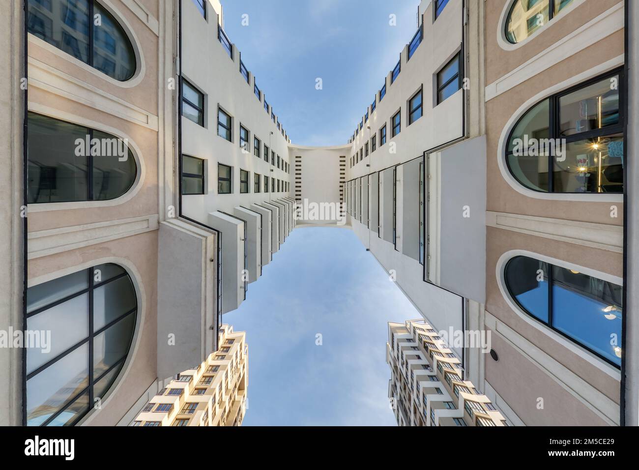 vue du sol au ciel bleu parmi les gratte-ciel, regardez la maison de bas en haut Banque D'Images