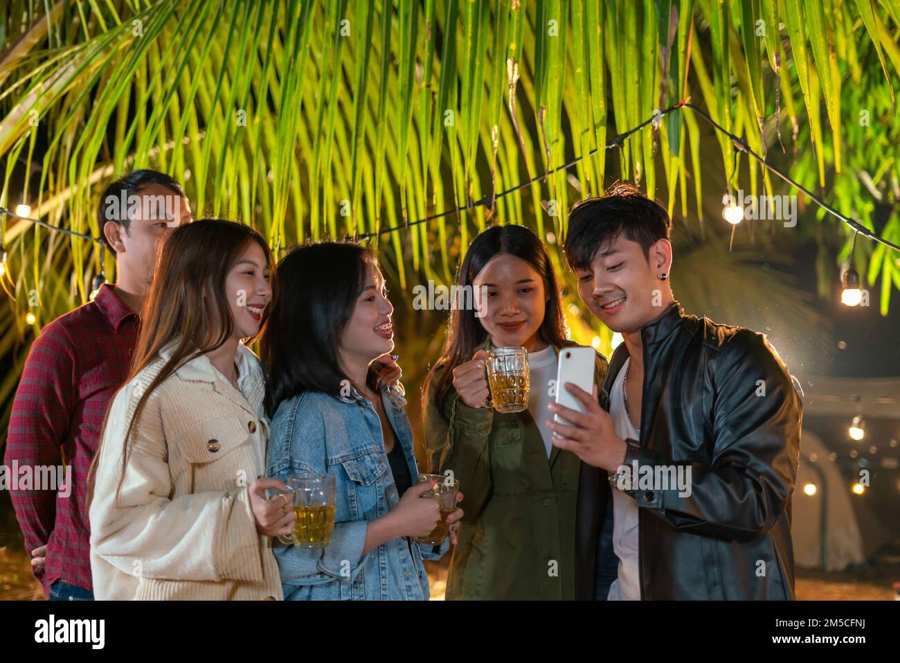Des jeunes asiatiques se joignent à des fêtes et font des appels vidéo pour se faire des amis. Banque D'Images
