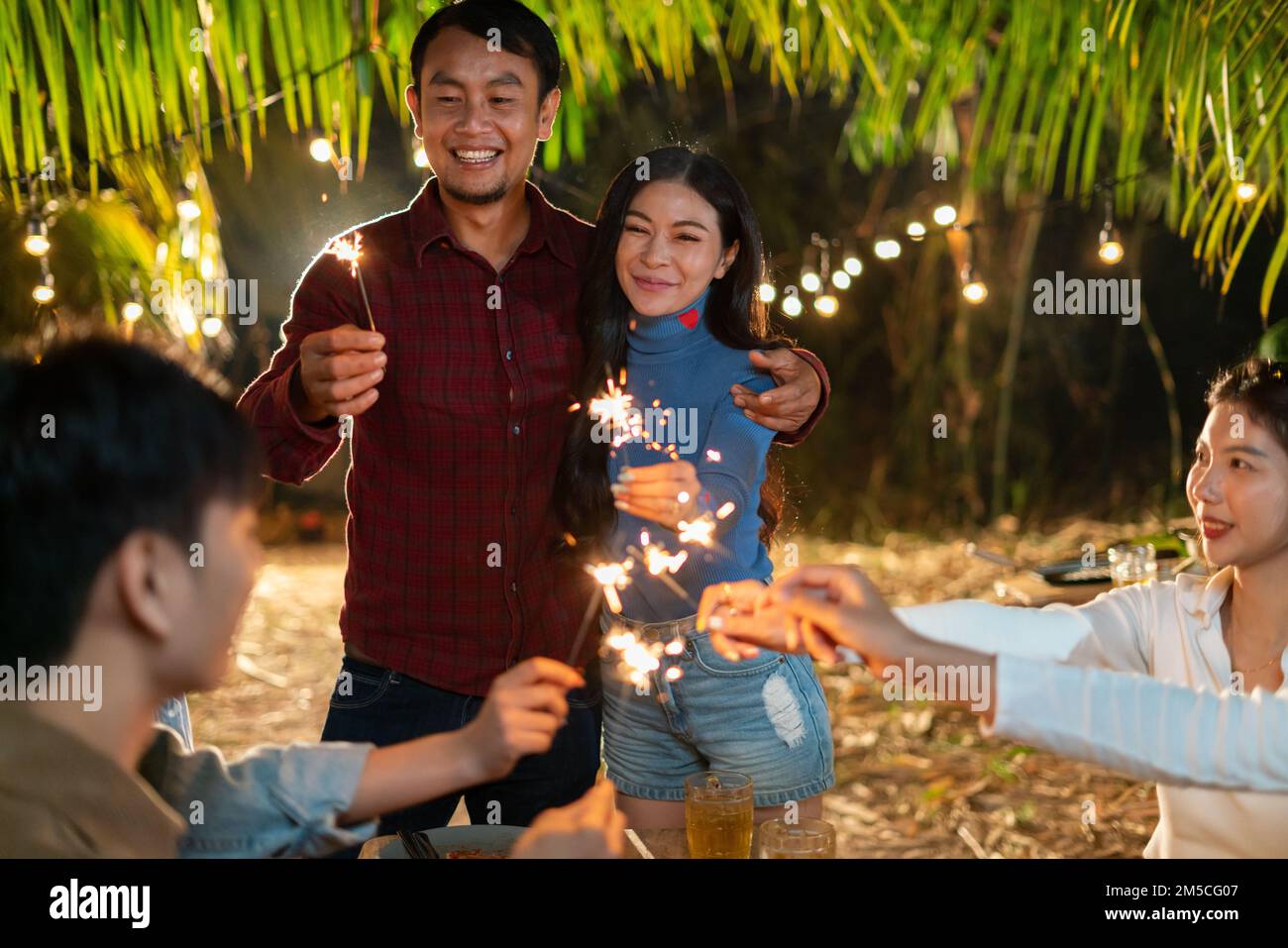 Les jeunes Asiatiques se réunissent pour faire la fête avec un sparkler Banque D'Images