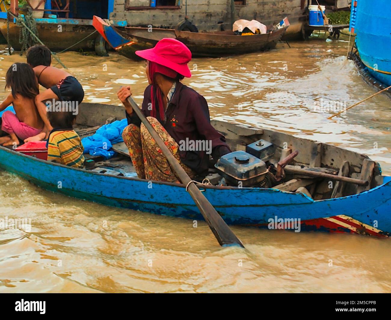 Siem Reap, Cambodge - 12 août 2010: Les Cambodgiens vivent sur Tonle SAP Lak, femme transportant des enfants sur le bateau . Banque D'Images